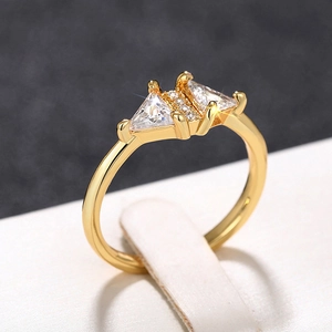 Macro view of gold triangle ring with micro-pave zircons on a white leather stand