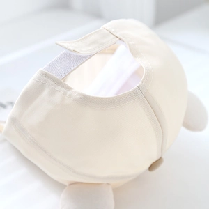 Detail of adjustable hook and loop fastener on beige cotton bear baseball cap