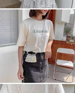 Detailed view of a handmade white pearl beaded mini crossbody bag on a model