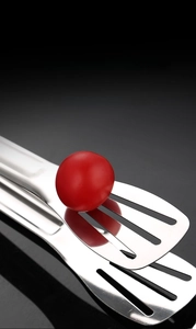Close-up of mirror-polished stainless steel food tongs with hollow head for oil drainage