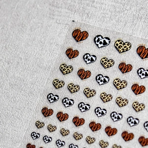 Detail of embossed heart nail stickers featuring tiger, leopard, and cow patterns