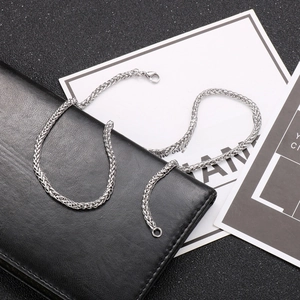 Detailed close-up of a silver spiga chain with a lobster clasp on a dark leather wallet