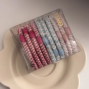 Detail of colorful braided elastic hair ties with glitter threads in a storage box
