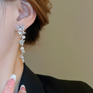 Elegant long tassel pearl earrings with marquise cubic zirconia on a model's ear