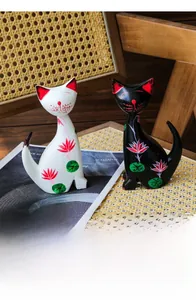 Artistic painted wooden cat figurines with lotus patterns on a rustic tray