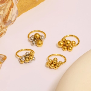 Luxurious 18K gold and silver stainless steel bead cluster rings on artistic display