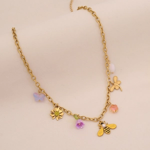 Detail of gold necklace with colorful butterfly, daisy, tulip, and bee charms on beige background