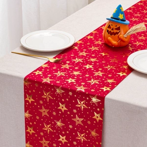 Detail of red velvet Christmas table runner with gold foil stars and snowflakes