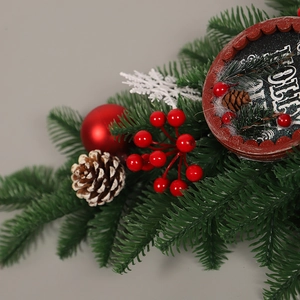 Décoration de Noël avec aiguilles de pin, baies rouges, pommes de pin et signe Jolly
