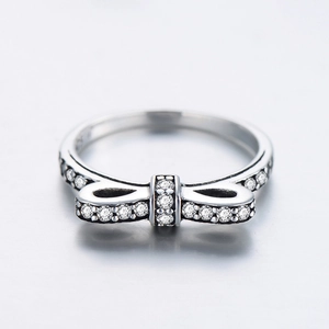 Sparkling S925 sterling silver bow ring with clear zircon stones on a gray background