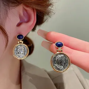 Vintage relief coin earrings with blue gemstone accents and golden metal frames