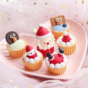 Detailed view of six Christmas themed resin cupcake charms on a pink heart plate