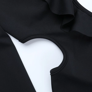 Detalle de un vestido negro con volantes, cuello en V y costuras caladas sofisticadas