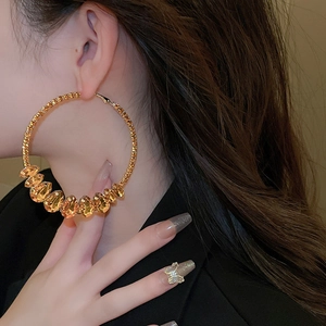Chic gold-plated geometric hoop earrings featuring amber crystal accents on model