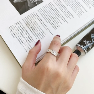 Close-up of wavy textured S925 silver ring with zircon stone on a model hand
