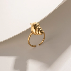 Macro shot of gold stainless steel shell ring with realistic ocean spiral texture