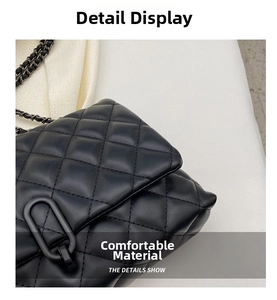 Detail view of black quilted leather chain bag with matte oval metal lock and stitching