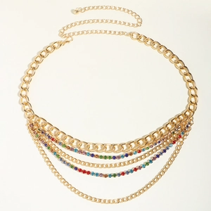Détail d'une chaîne de taille dorée multicouche avec strass colorés et maillons