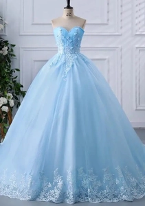 Detail of light blue strapless ball gown featuring lace appliques and tulle skirt layers
