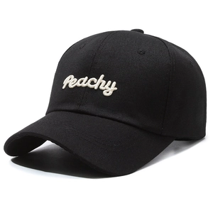 Black cotton baseball cap with white Peachy embroidery and curved brim in side view
