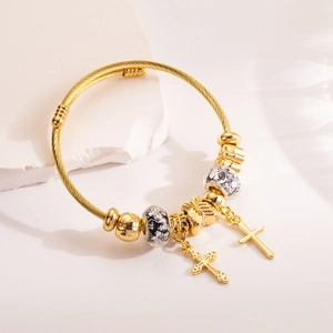 Golden woven cable bracelet with floral beads, butterfly charm and double cross pendants