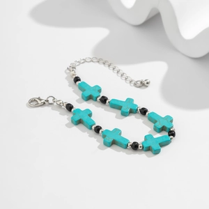 Detail of turquoise cross bead bracelet with black beads and adjustable lobster clasp