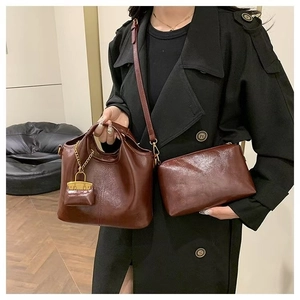 Retro brown oil wax leather tote and pouch set shown on model wearing a black trench coat