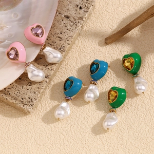 Detailed shot of heart-shaped baroque pearl earrings with colorful glaze and crystals