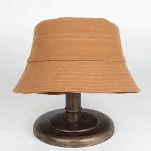 Chapeau bob en toile kaki avec surpiqûres sur un support à chapeau en bois