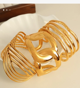 Detail of 18K gold plated titanium steel wide cuff bracelet with layered geometric chain design