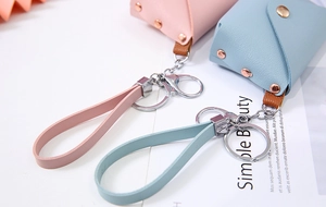 Close-up of mini PU leather keychain wallets in pink and blue with cross grain texture