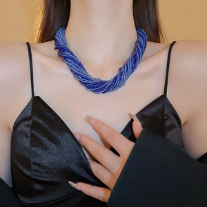 Dettaglio della collana di perline blu a più fili intrecciati in stile boho sul collo