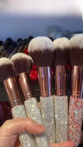 Detail of luxury rhinestone makeup brush handle with rose gold ferrule and dual-tone bristles