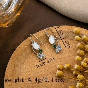 Close-up of vintage feather turquoise earrings with silver base and white oval gemstone