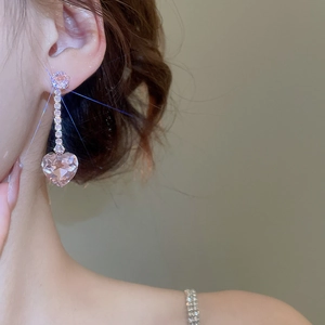 Detailed view of long tassel earrings with pink heart zircon crystals on model