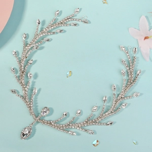 Exquisite silver bridal forehead chain with rhinestone leaves on a light blue background