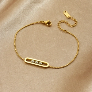 Gold plated stainless steel oval pendant bracelet with three sparkling zircons on champagne silk