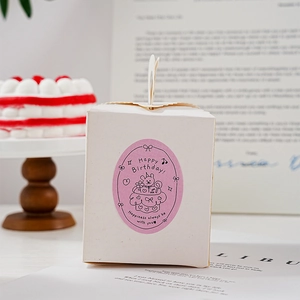 Detail of Happy Birthday oval sticker on a white gift box for small cakes and pastries