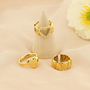 Three-piece gold heart ring set including solid and hollow rhinestone-set designs
