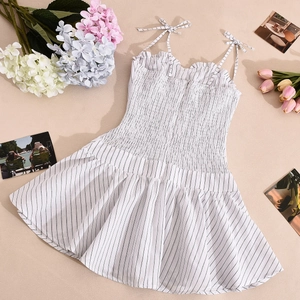 Detail of smocked bodice and bow shoulder straps on a striped summer sundress