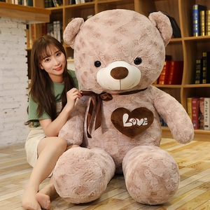 Detail of soft plush teddy bear with silk bow tie and Love heart patch embroidery