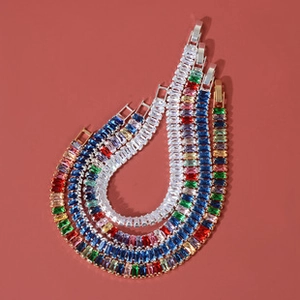 Detail shot of multicolor crystal teardrop bracelets in gold finish on red background
