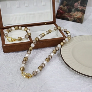 Three-tone pearl necklace and bracelet set with an elegant gold clasp and wooden box