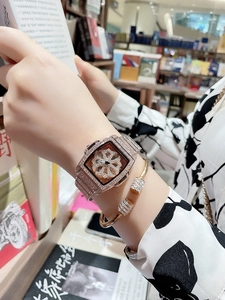 Close-up of luxury tonneau-shaped watch and open bracelet with full diamond settings
