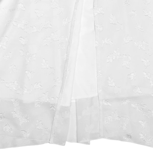 Detailed macro view showing the intricate floral embroidery on white dress fabric texture