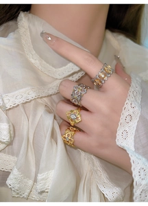 Détail de bagues fleurs en losange plaquées or avec zircons au style vintage chic