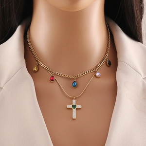 Detail of gold double-layer necklace with colorful drop stones and crystal cross pendant