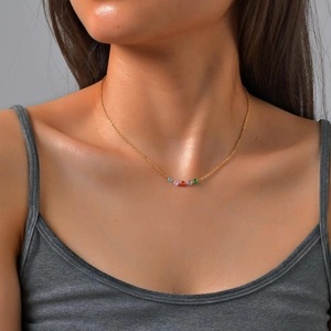 Detail shot of a gold stainless steel necklace with five colorful round zircon beads