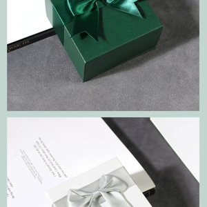 Close-up of premium textured gift boxes featuring satin bows in dark green and white