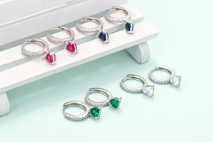 Detail of colorful heart-shaped zircon earrings in red blue green and clear crystals
